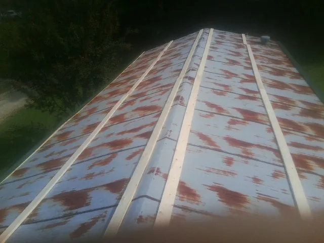 Rusted metal roof panels with new wood purlins before replacement — Storm Damage Roof Repair in Green Ridge by Roofing Brothers