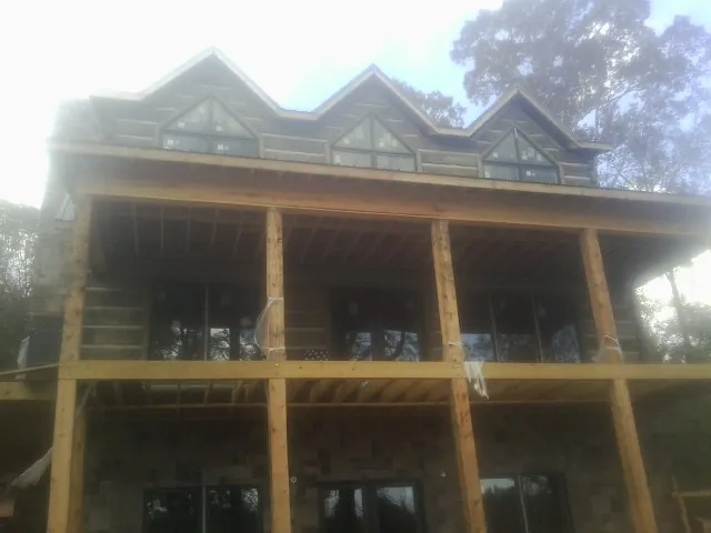 Dormers and porch framing on a large log home under construction — Roof Coating work by our crew in Green Ridge
