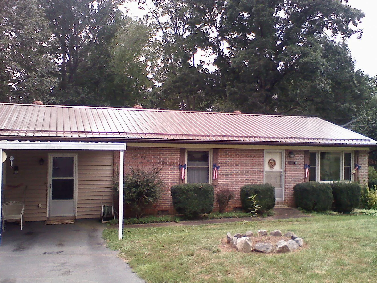 Bronze metal roof and carport on a brick ranch home — Roof Repair work by our crew in Green Ridge