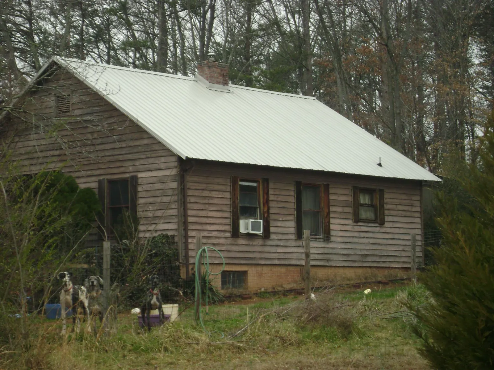 White metal roof on an old wood sided farmhouse, from a Metal Roof Installation job in Green Ridge